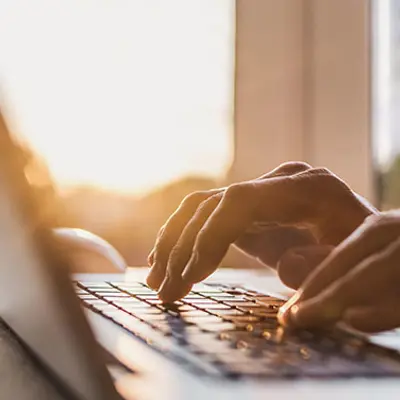 closeup of hands typing on a laptop