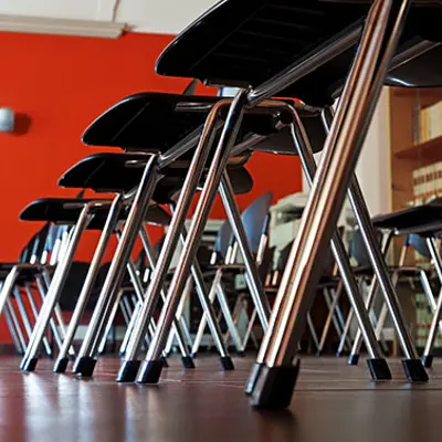 a group of stackable chairs in a room with a red wall